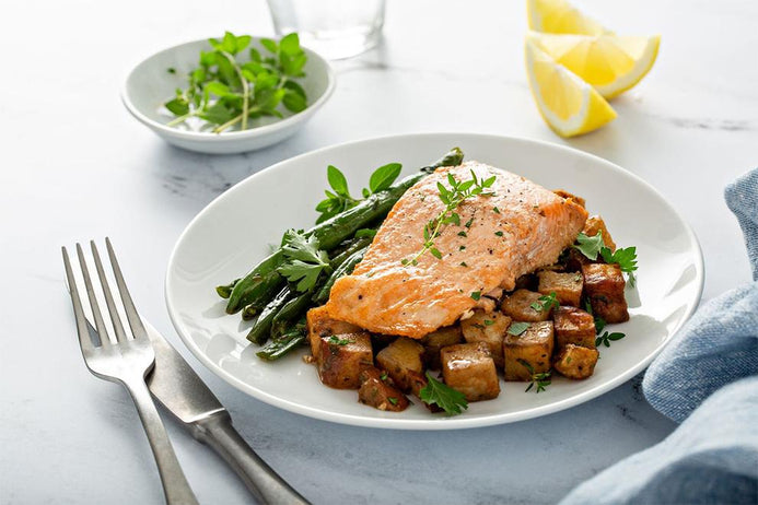 a plate of chicken and potatoes with asparagus